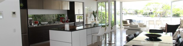 An image of a white contemporary kicthe whihc has the addition of grey cabinets and integrated appliances.
