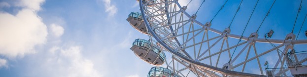 An image of the London eye, taken from the ground on a sunny day.