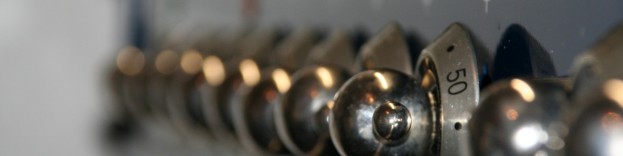 A close up image of silver oven dials on an oven in a kitchen