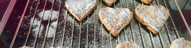 An image of freshly made Christmas biscuits on a baking tray.